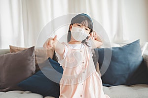 little girl wearing face mask show thumb up