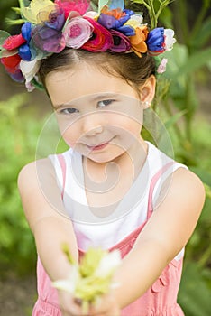 Little girl wearing flower wreath and bouquet of flower