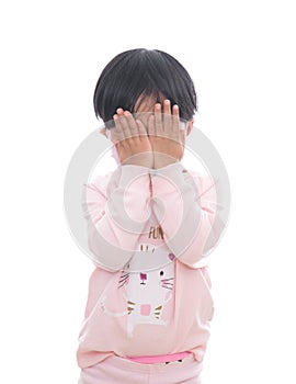 Little girl wearing mask in front of white background covers her face with hands