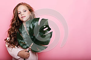 Little girl wearing pink outfit and holding flower