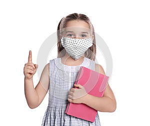 Little girl wearing protective mask with book on white background. Child safety