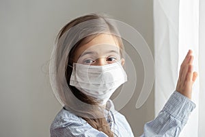 Little girl wearing a protective medical mask from coronavirus close up
