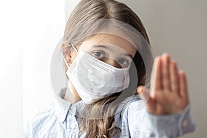 Little girl wearing a protective medical mask from coronavirus close up