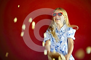 Little girl wearing sunglasses and eating popcorn