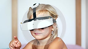 Little girl wearing virtual reality glasses, playing video games Cheerful smiling, looking in VR glasses and hand