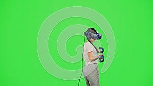 The little girl wearing VR headset dancing in virtual reality. The child dancing on chroma key green screen background