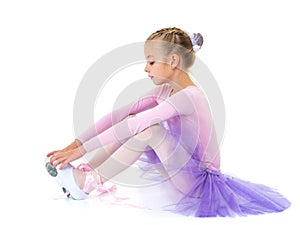 Little girl wears ballet shoes.