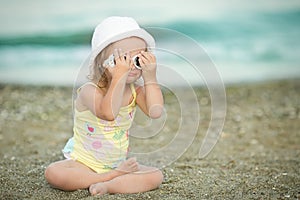 Little girl wears glasses at the beach