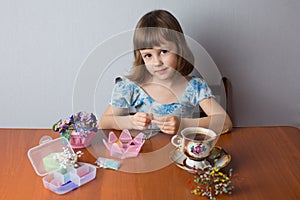 Little girl weaves bead jewelry