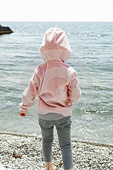 little girl wets her feet in the sea
