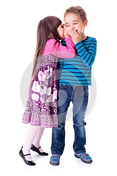 Little girl whispering into boy's ear