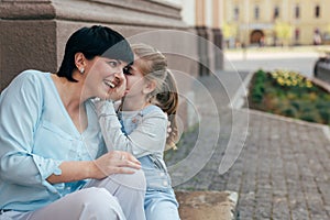 Little girl whispering to her mother