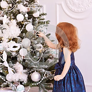 Little girl. White background. Blue dress. Christmas decorations