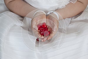 Communion girl dressed in white with hearts in her hands