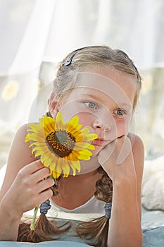 Little girl in white chiffon tent with sunflower
