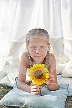 Little girl in white chiffon tent with sunflower