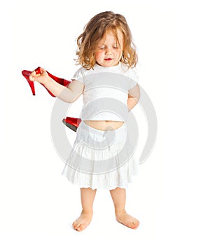 Little girl in white dress with big red shoes