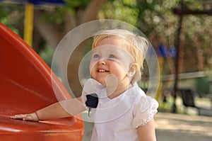 Little girl in white dress on playground