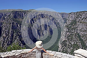 Little girl with white hat on the viewpoint Vikos gorge