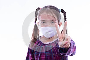 Little girl in a white mask with fingers shows a peace