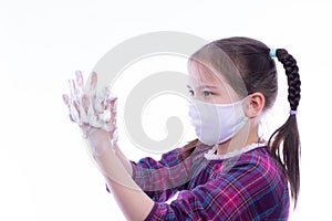 Little girl in a white mask soaped her hands with fragrant soap