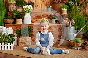 Little girl with white rabbit. Child playing with pet bunny. Kids play with animals. Child at Easter egg hunt. Cute little girl wi
