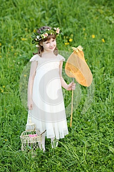 Little girl in white stands with butterfly net and