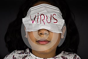 Little girl in white surgical mask covers her eyes and leaves her nose and mouth free. Concept of ignorance and happiness in the