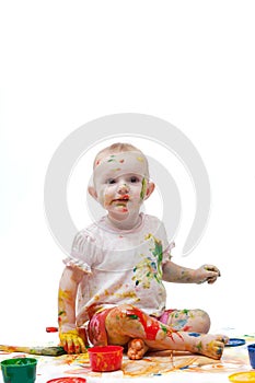 Little girl in a white t-shirt soiled by bright paints