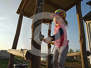 Little girl whitewash oak barrel of children`s slide on playground, sunset