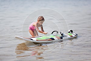 Little girl and windsurfing board