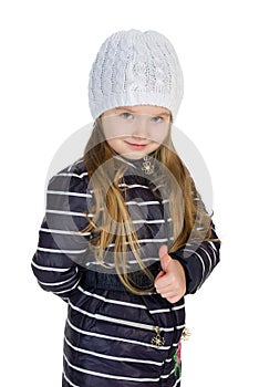 Little girl in a winter coat holds her thumb up