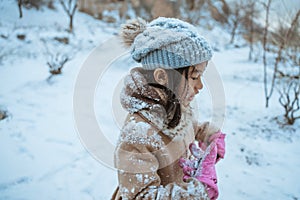 little girl in winter wearing coat full of snow