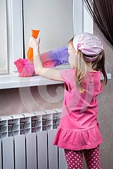 Little girl wipes dust with brush