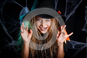 Little girl in witch costume having fun on Halloween trick or treat.
