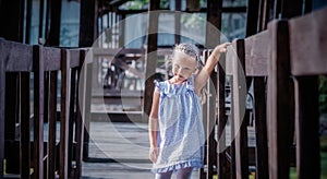 Little girl on a wooden bridge