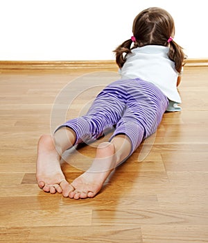 A little girl on a wooden floor