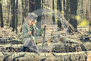 Little girl in the woods sitting on a stump