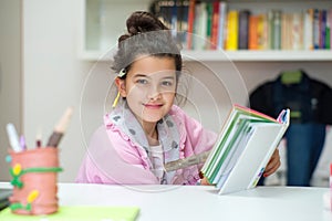 Little girl writes on the school diary photo