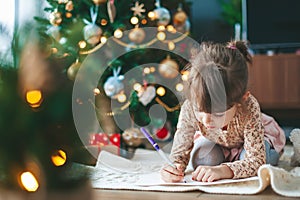 Little girl writing a letter to Santa Claus