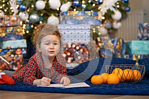 Little girl writing letter to santa. happy kid making a wish, gift, present on new year eve. child dreaming under the christmas