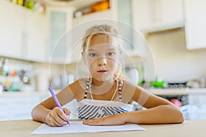 Little girl writing with pen in notebook