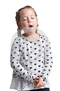 A little girl yawns with eyes closed. Isolated on white background.