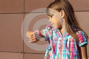 Little girl of 6 7 years looking at smart watch to to see who does calling