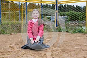 Little girl yelling out of a black trash bag playing outdoors