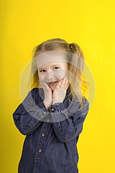 Little girl on a yellow background. emotion. surprise