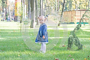 Little girl with yellow leaf. Child playing with autumn golden leaves. Kids play outdoors in the park. Children hiking in fall for