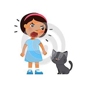 Little girl yells at a sad kitten. Psychology - concept of aggressive treatment of pets. photo