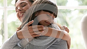 Little girl and young mom hug showing love and care