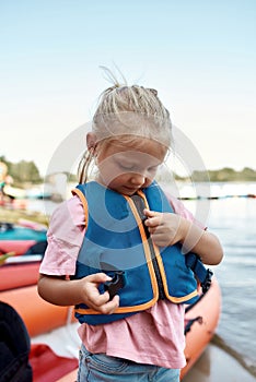 Little girl zipping life west on river coast